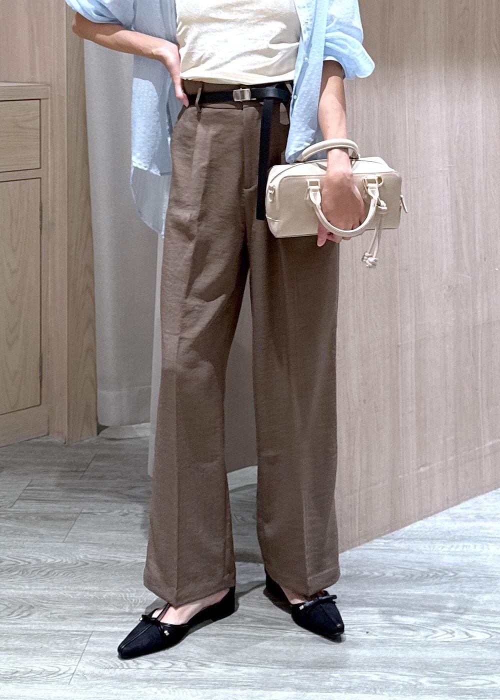 グリーン系のスラックス、ブラック系のパンプス、ベージュ系のボストンバッグを着用したレディースの秋コーディネートの6枚目の写真