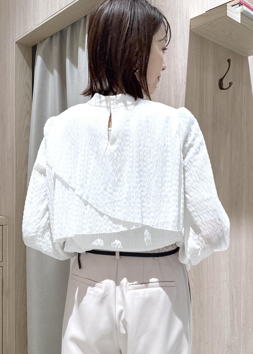 ブラック系のショルダーバッグ、ホワイト系のシャツ/ブラウス、ベージュ系のその他パンツを着用したレディースの冬コーディネートの7枚目の写真