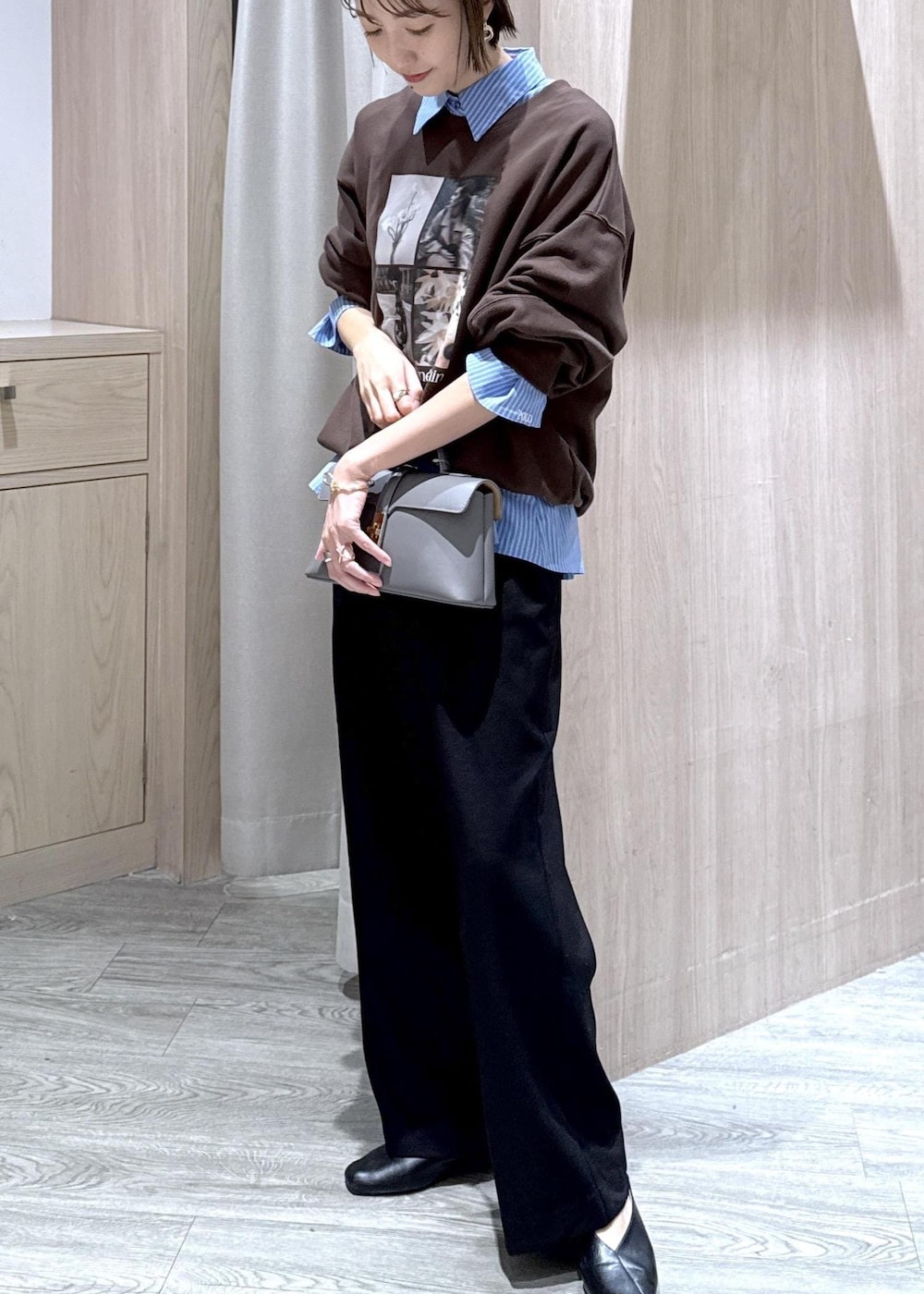 グレー系のショルダーバッグ、ブラック系のスラックス、ブルー系のシャツ/ブラウスを着用したレディースの秋コーディネートの4枚目の写真