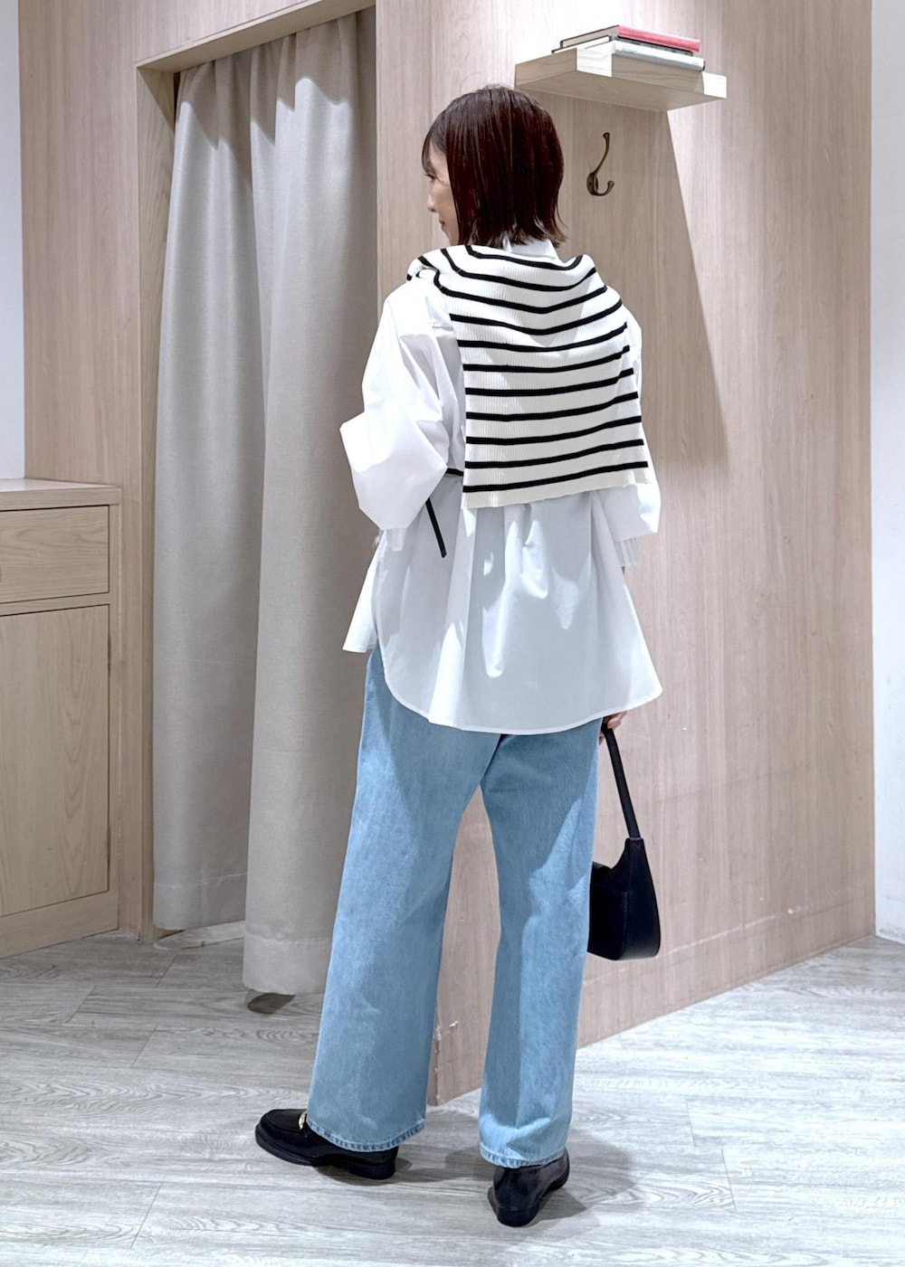 ブラック系のハンドバッグ、ブラック系のローファー、ホワイト系のシャツ/ブラウスを着用したレディースの春コーディネートの3枚目の写真