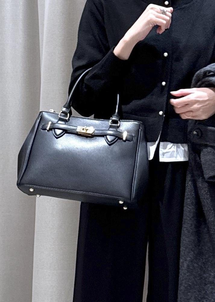 ブラック系のショルダーバッグ、ブラック系のスラックス、グレー系のその他アウターを着用したレディースの冬コーディネートの5枚目の写真