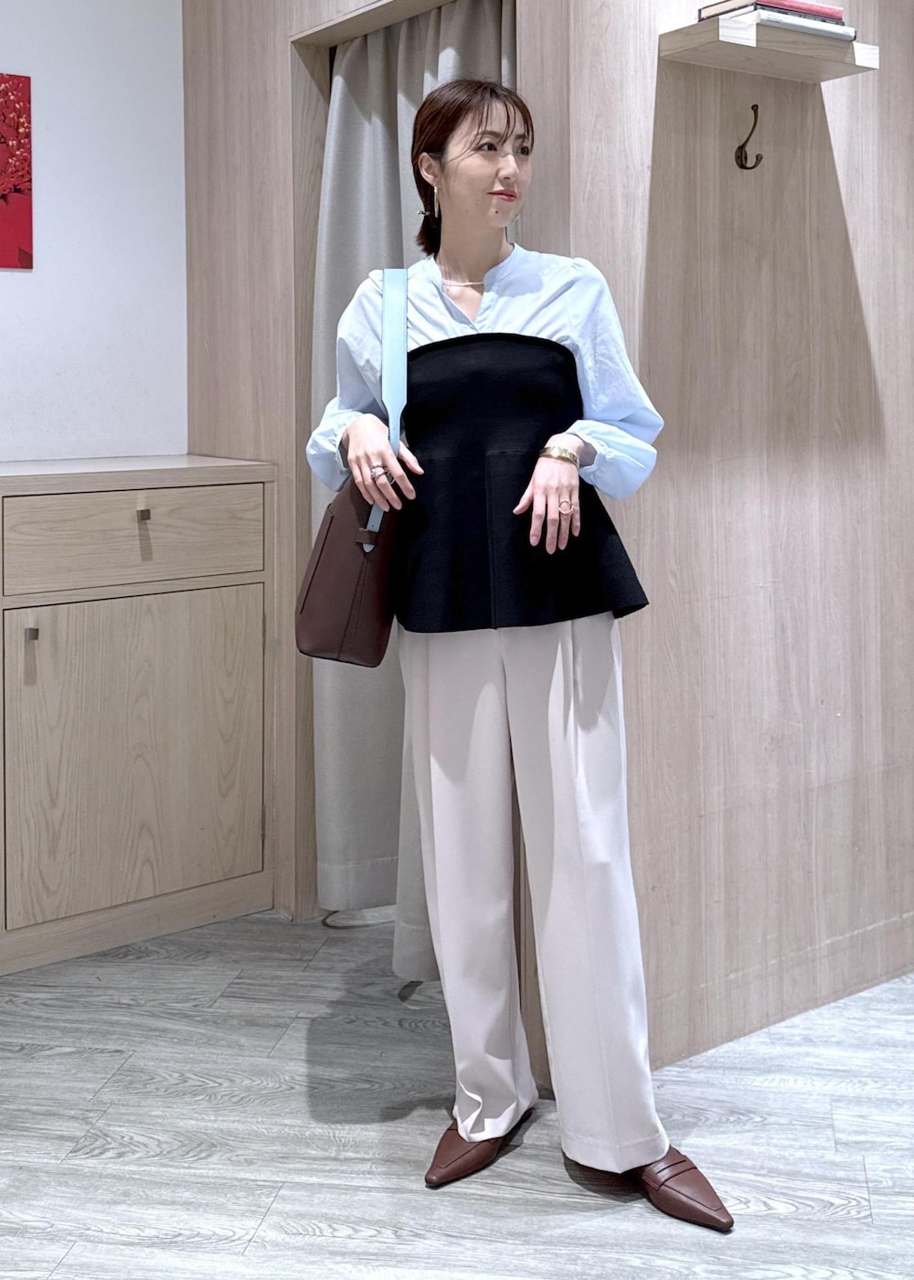 ブラウン系のトートバッグ、ベージュ系のその他パンツ、ブラック系のシャツ/ブラウスを着用したレディースの春コーディネートの2枚目の写真