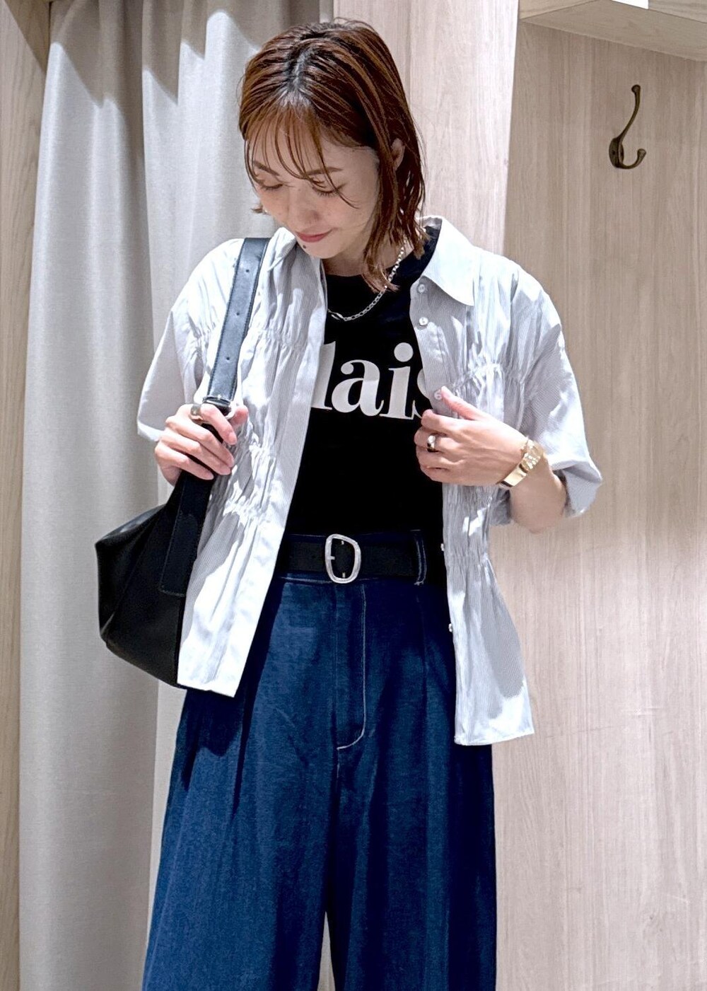 ブラック系のショルダーバッグ、ブラック系のサンダル、ブルー系のデニムパンツを着用したレディースの夏コーディネートの7枚目の写真