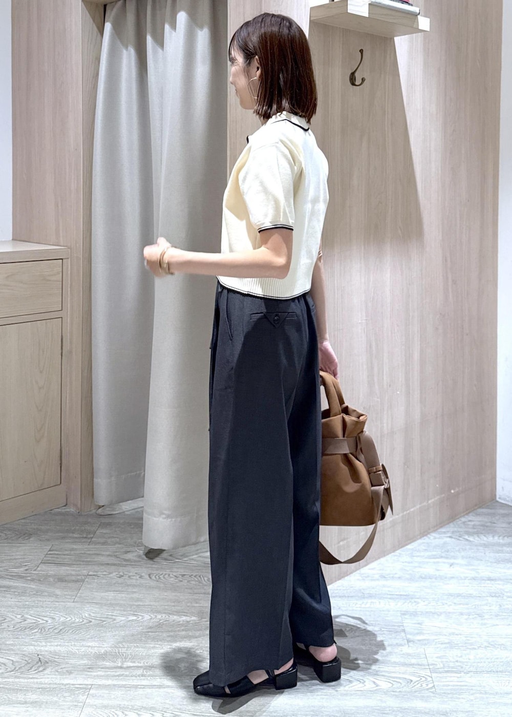 グレー系のその他パンツ、ブラウン系のトートバッグ、ホワイト系のニット/セーターを着用したレディースの夏コーディネートの2枚目の写真