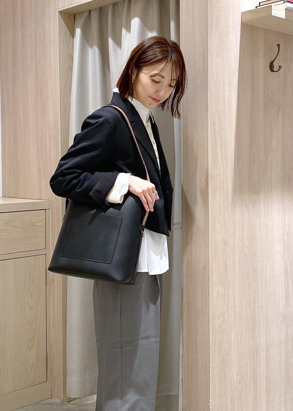 ブラック系のショルダーバッグ、グレー系のスラックス、ホワイト系のカーディガン/ボレロを着用したレディースの冬コーディネートの6枚目の写真