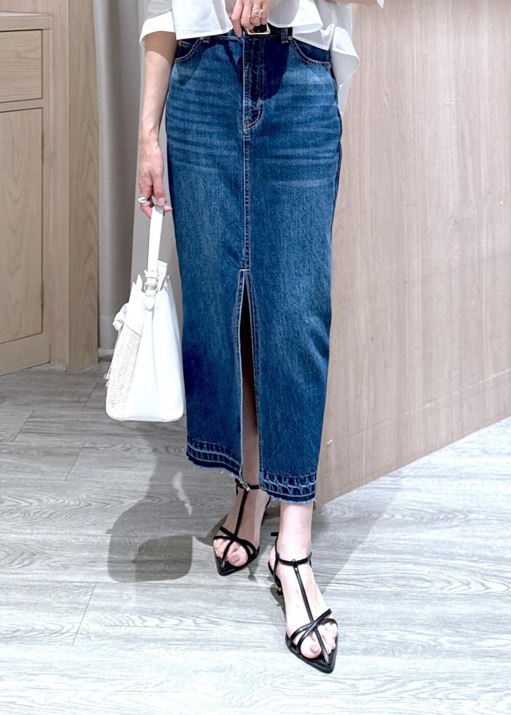 ブルー系のデニムスカート、ベージュ系のキャミソール、ブラック系のサンダルを着用したレディースの夏コーディネートの6枚目の写真