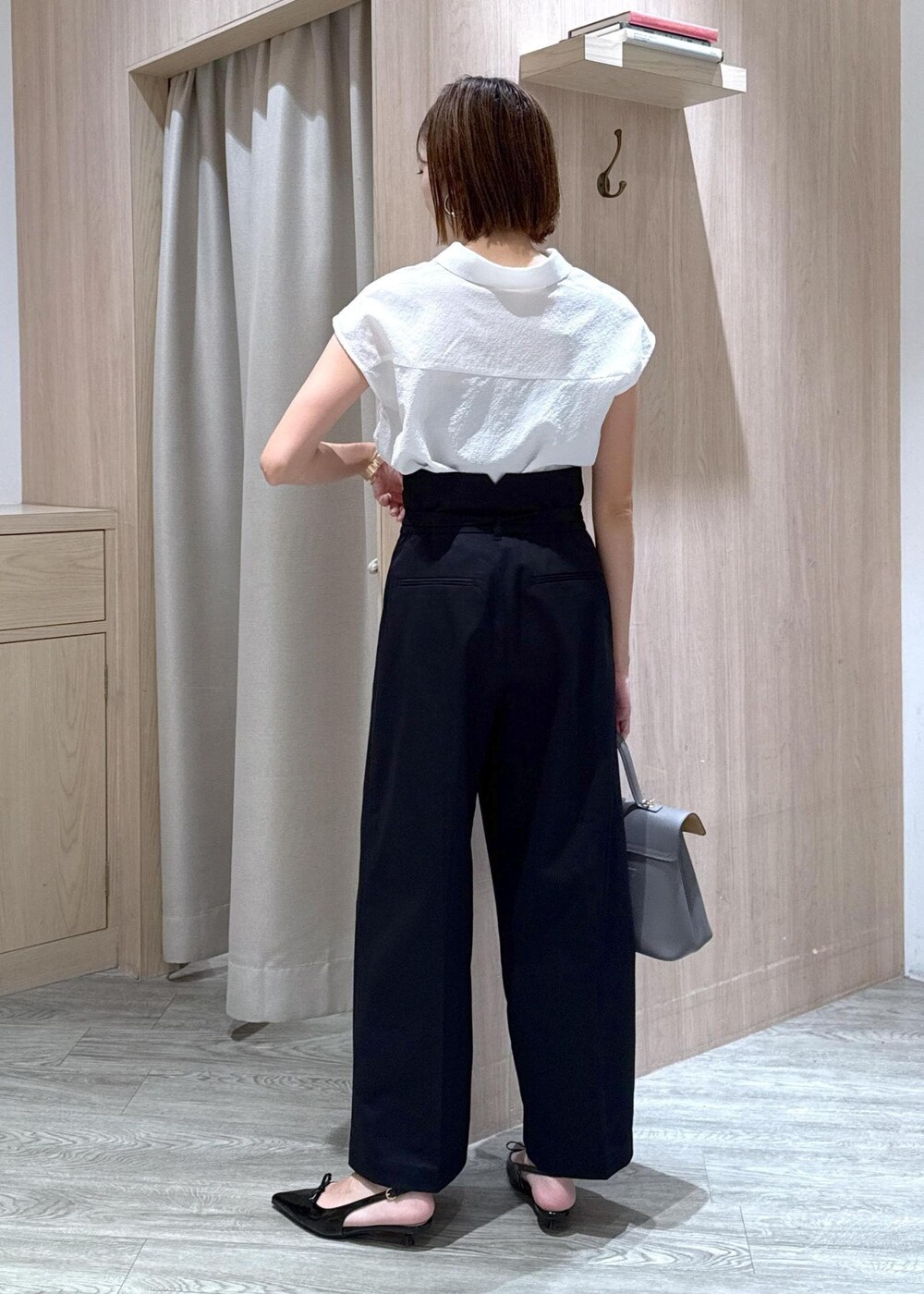 グレー系のハンドバッグ、ブラック系のパンプス、ベージュ系のキャミソールを着用したレディースの夏コーディネートの3枚目の写真