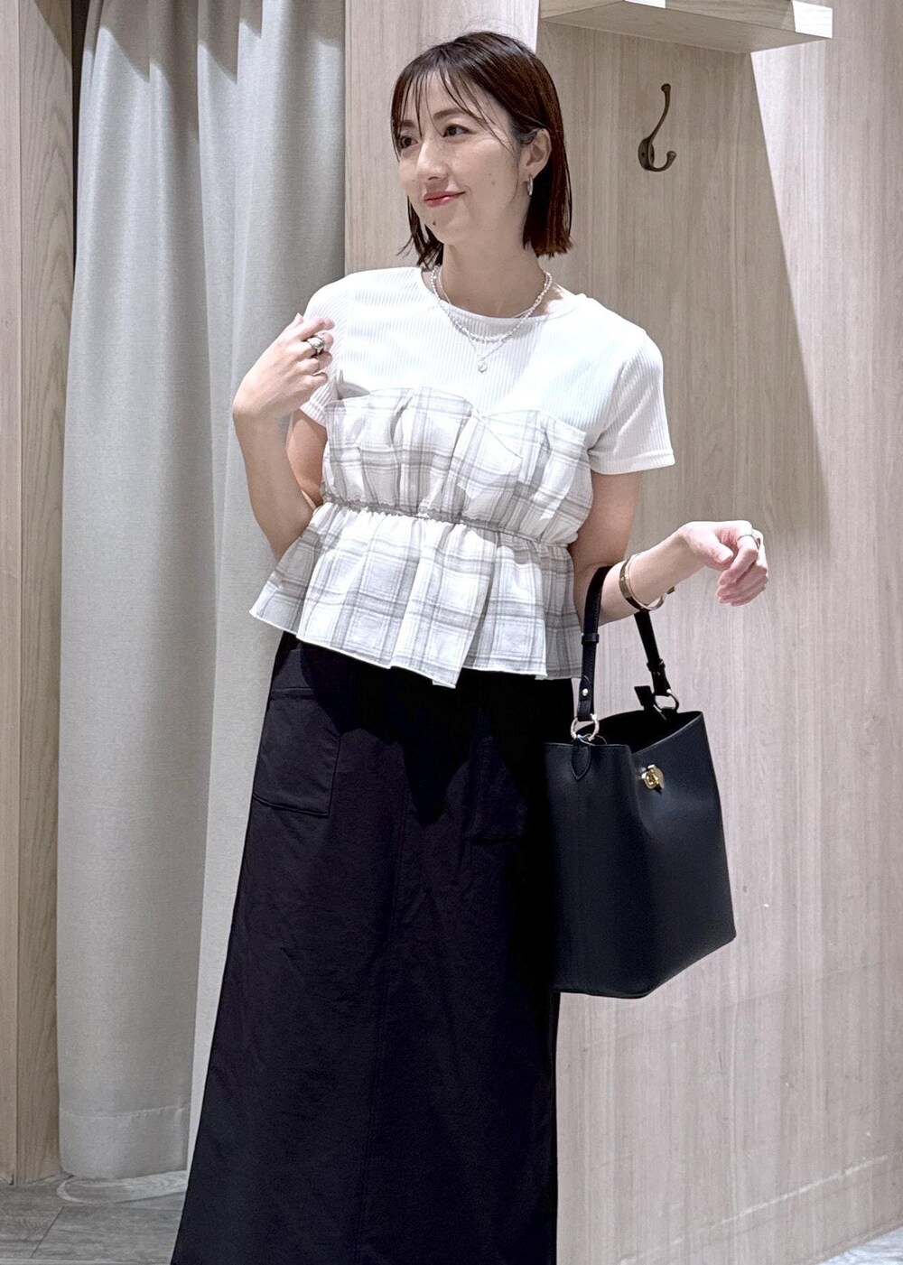 ブラック系のパンプス、ブラック系のスカート、ホワイト系のTシャツ/カットソーを着用したレディースの春コーディネートの5枚目の写真