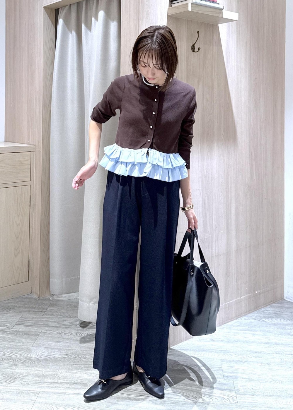 ブラック系のパンプス、ブルー系のその他パンツ、ブラック系のビジネスバッグを着用したレディースの秋コーディネートの10枚目の写真
