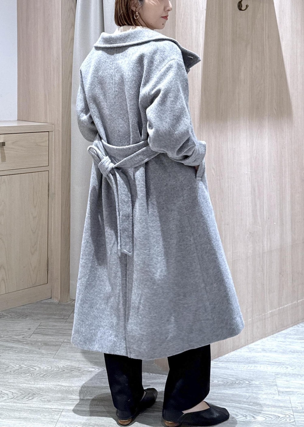 ホワイト系のニット/セーター、グレー系のその他アウター、ブラック系のスラックスを着用したレディースの冬コーディネートの10枚目の写真