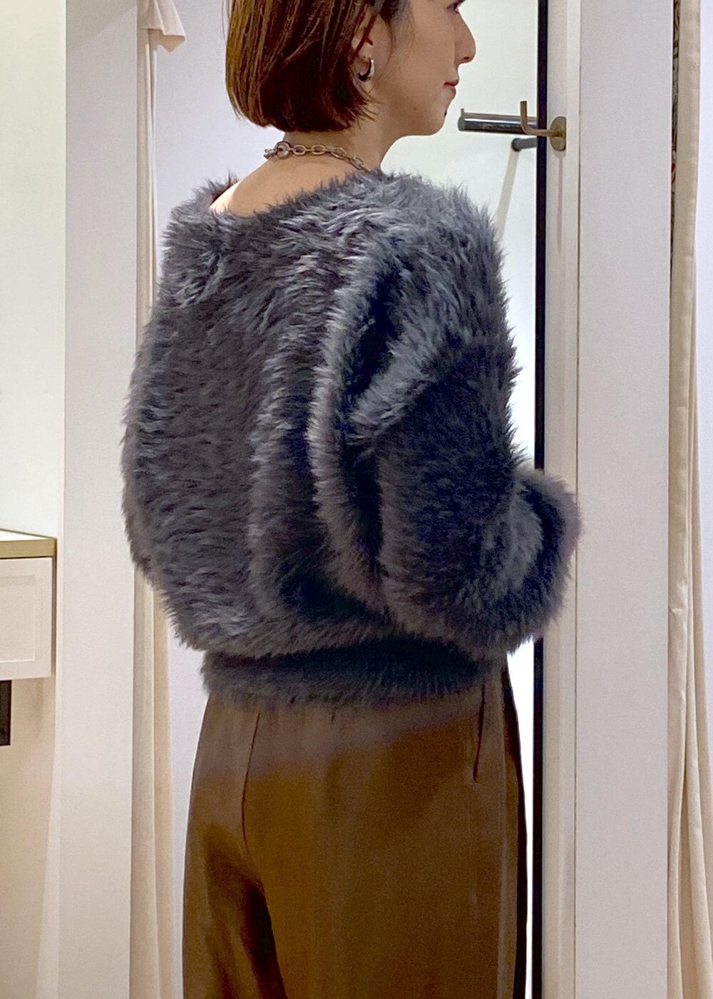 ブラック系のショルダーバッグ、ブラック系のブーツ、グレー系のカーディガン/ボレロを着用したレディースの冬コーディネートの9枚目の写真