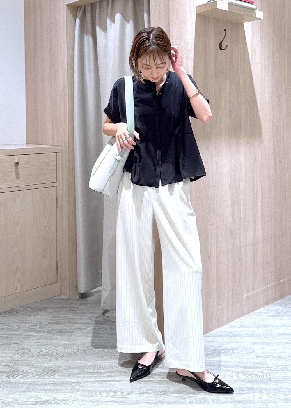 ブラック系のパンプス、ベージュ系のキャミソール、ブラック系のシャツ/ブラウスを着用したレディースの夏コーディネートの5枚目の写真