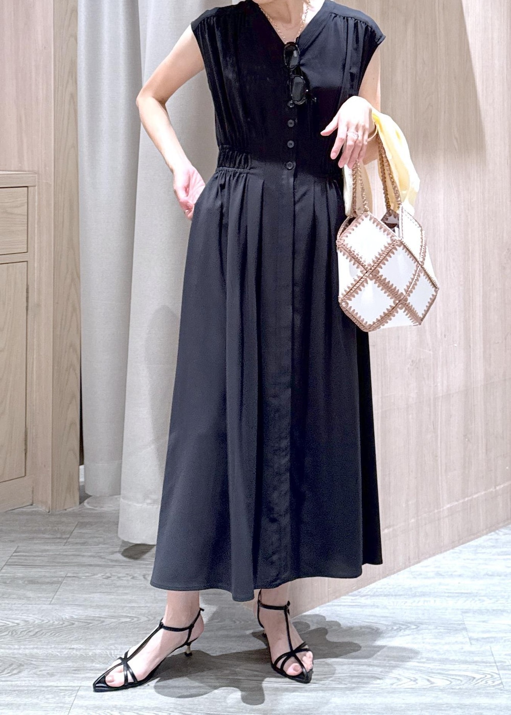 ブラック系のサンダル、ホワイト系のハンドバッグ、ホワイト系のカーディガン/ボレロを着用したレディースの春コーディネートの6枚目の写真