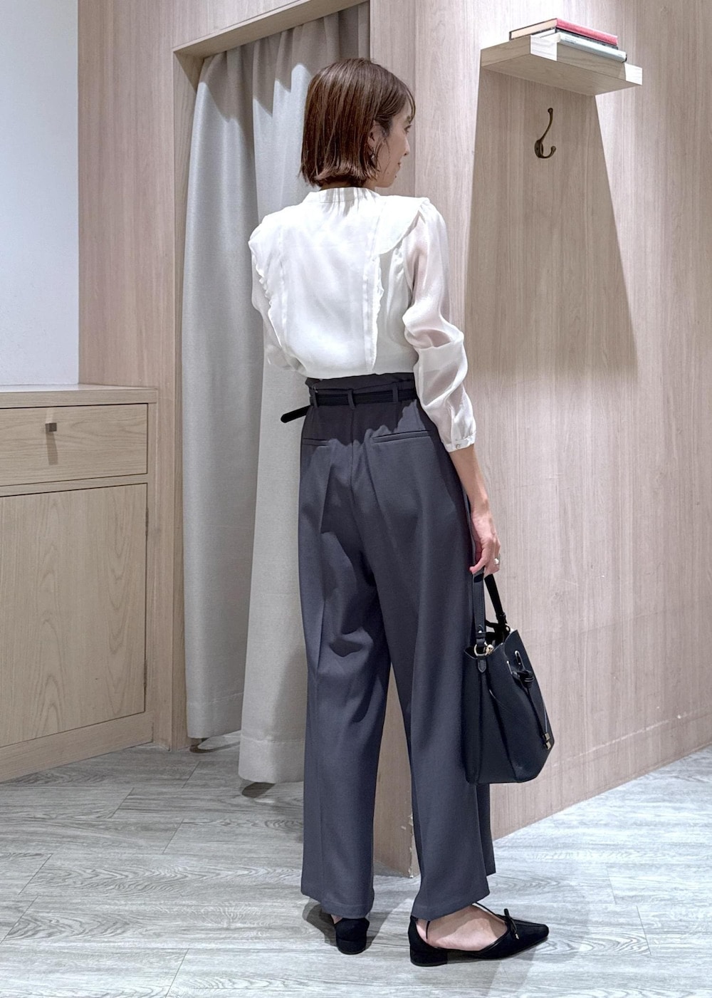 ブラック系のショルダーバッグ、グレー系のスラックス、ホワイト系のシャツ/ブラウスを着用したレディースの秋コーディネートの4枚目の写真