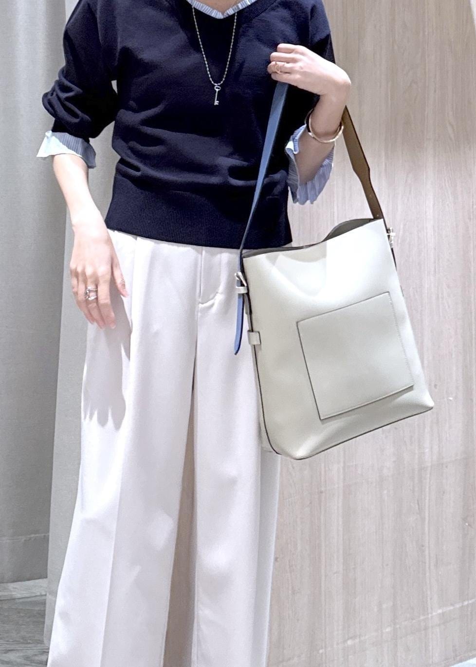 ベージュ系のトートバッグ、ベージュ系のその他パンツ、ブルー系のニット/セーターを着用したレディースの冬コーディネートの5枚目の写真