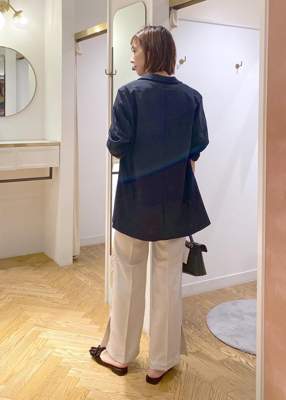 ブルー系のテーラードジャケット、ホワイト系のスラックス、その他のショルダーバッグを着用したレディースの夏コーディネートの3枚目の写真