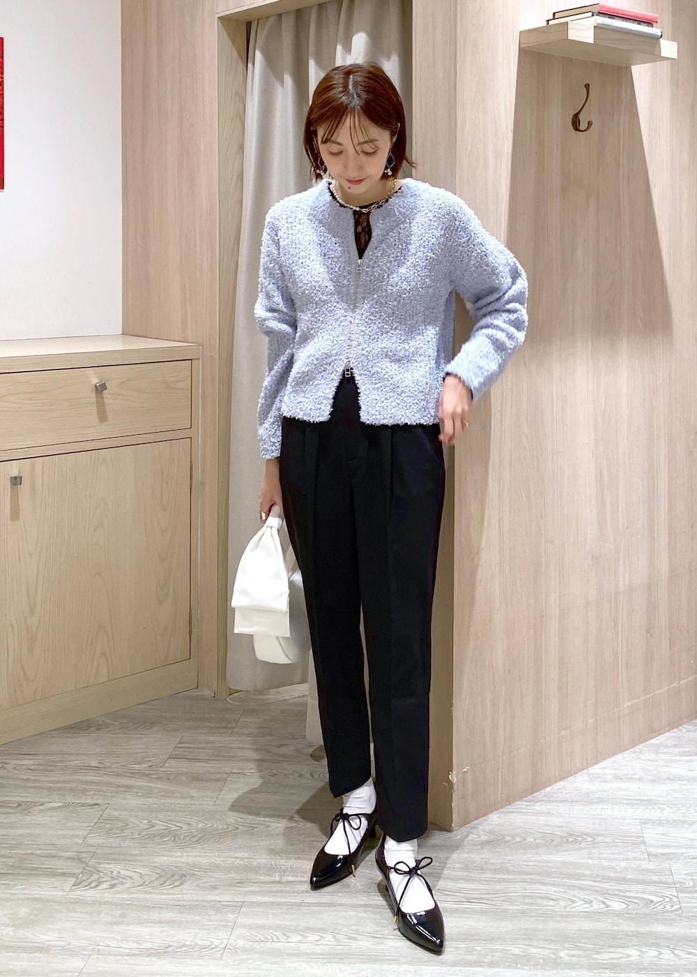 ブラック系のパンプス、ブルー系のカーディガン/ボレロ、ブラック系のTシャツ/カットソーを着用したレディースの冬コーディネートの2枚目の写真