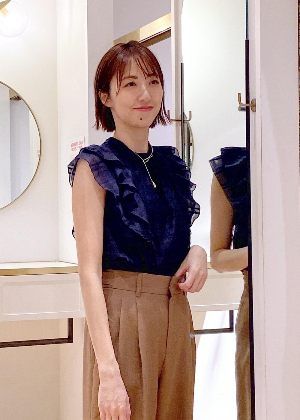 ブラック系のパンプス、ホワイト系のキャミソール、ホワイト系のハンドバッグを着用したレディースの春コーディネートの6枚目の写真