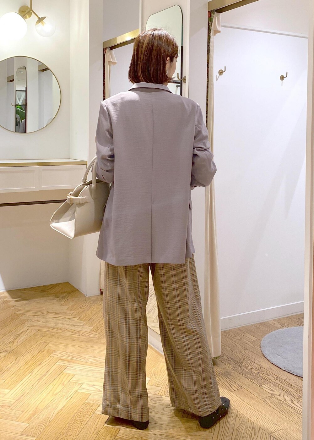 グレー系のテーラードジャケット、ブラック系のバレエシューズ、ベージュ系のトートバッグを着用したレディースの秋コーディネートの3枚目の写真