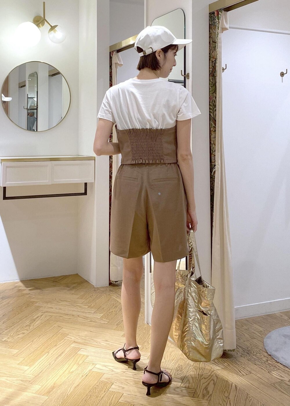 ブラック系のサンダル、ゴールド系のトートバッグ、ブラウン系のTシャツ/カットソーを着用したレディースの夏コーディネートの3枚目の写真