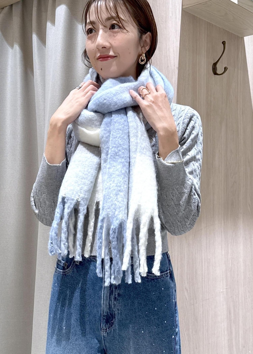 グレー系のカーディガン/ボレロ、ブラック系のブルゾン、ブルー系のデニムパンツを着用したレディースの秋コーディネートの6枚目の写真