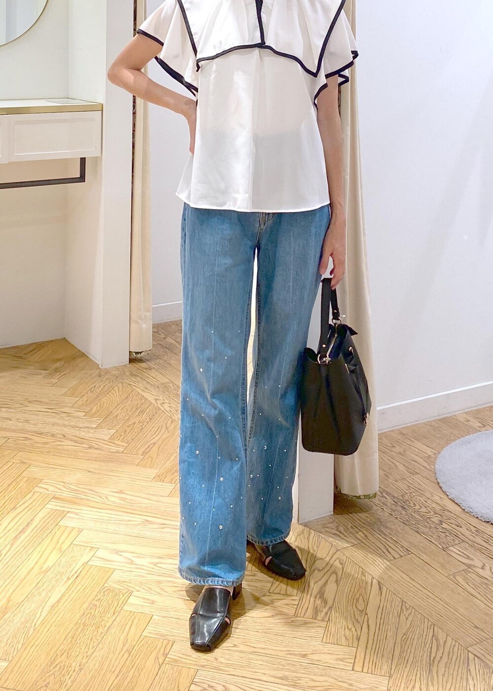 ブラック系のサンダル、ホワイト系のキャミソール、ブルー系のデニムパンツを着用したレディースの夏コーディネートの4枚目の写真