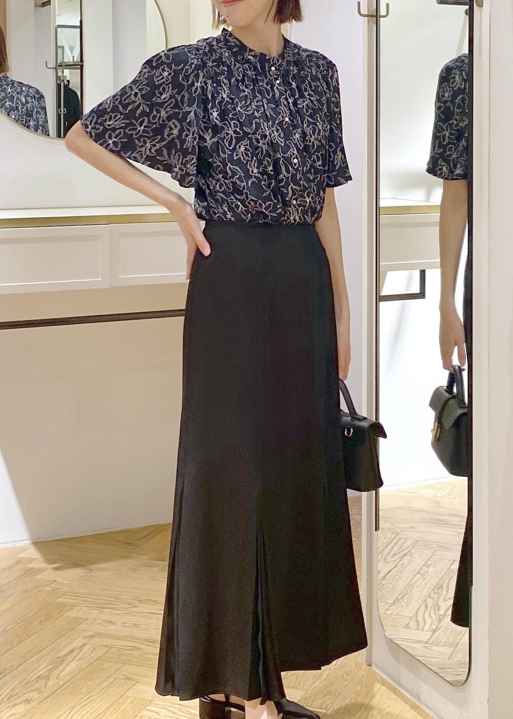 ブラック系のキャミソール、ブラック系のサンダル、ブラック系のスカートを着用したレディースの春コーディネートの5枚目の写真