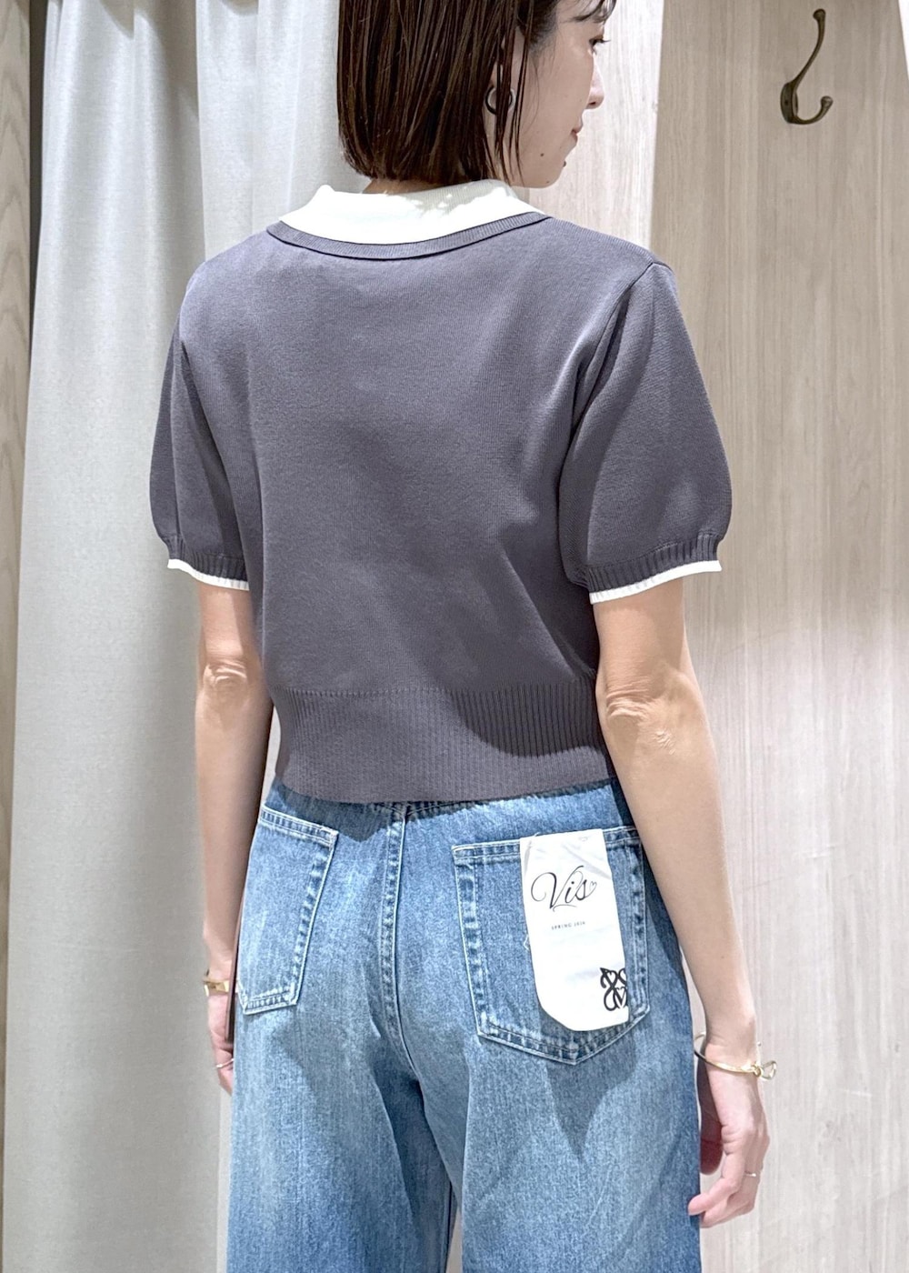 ホワイト系のキャミソール、ブラック系のトートバッグ、ブルー系のデニムパンツを着用したレディースの春コーディネートの7枚目の写真