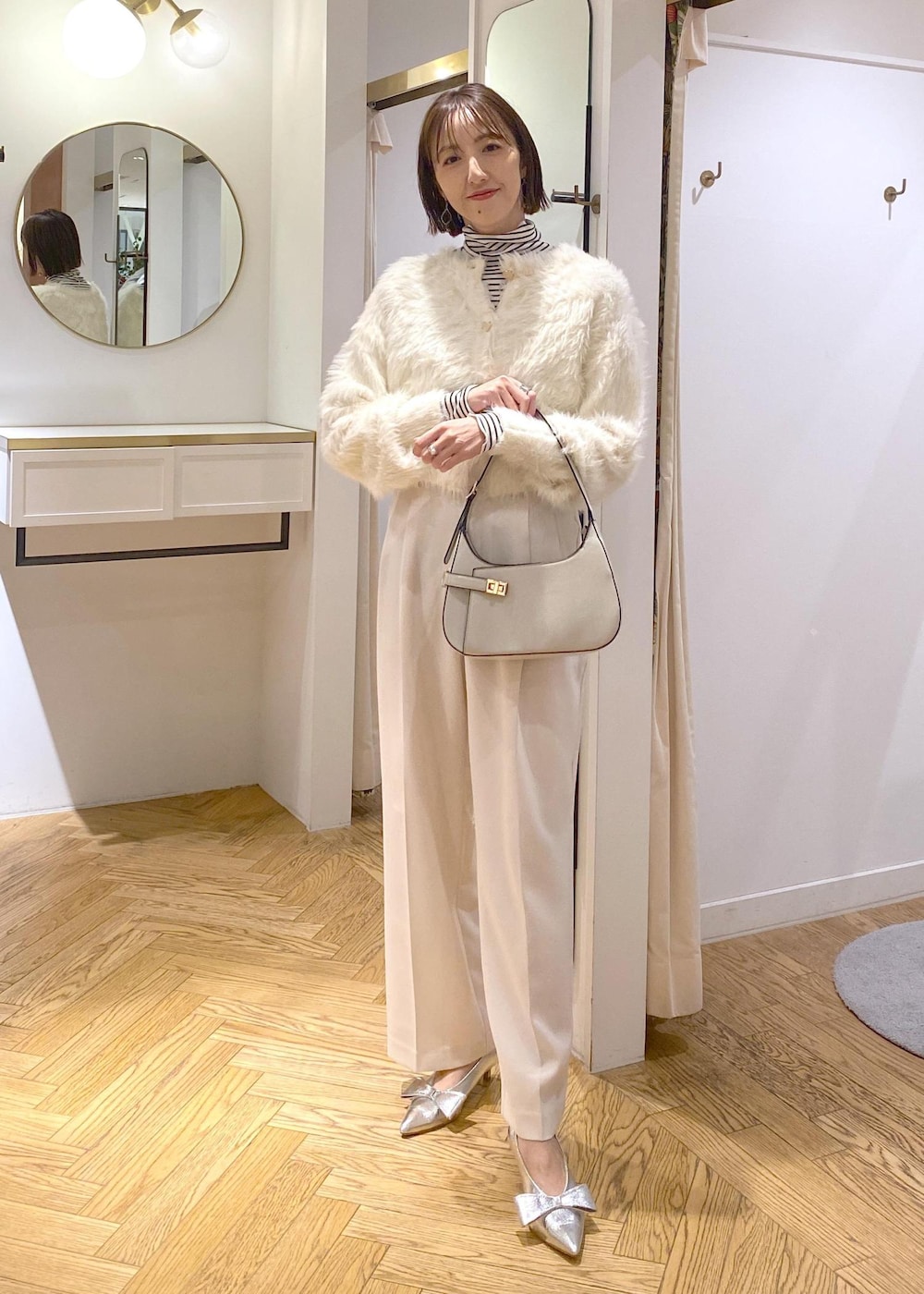 シルバー系のパンプス、ホワイト系のカーディガン/ボレロ、ホワイト系のTシャツ/カットソーを着用したレディースの冬コーディネートの4枚目の写真