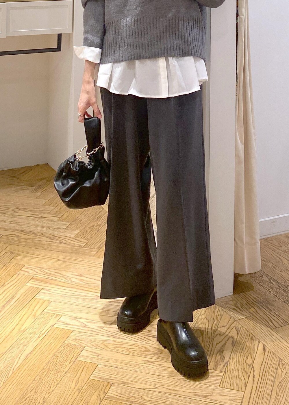 ブラック系のブーツ、ホワイト系のシャツ/ブラウス、グレー系のニット/セーターを着用したレディースの冬コーディネートの6枚目の写真