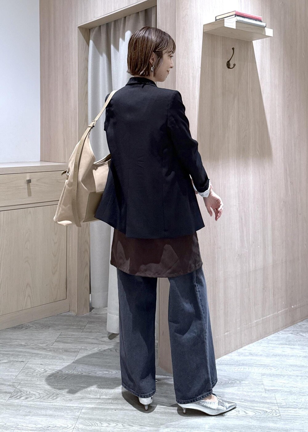 シルバー系のパンプス、ベージュ系のショルダーバッグ、ブラック系のテーラードジャケットを着用したレディースの秋コーディネートの3枚目の写真