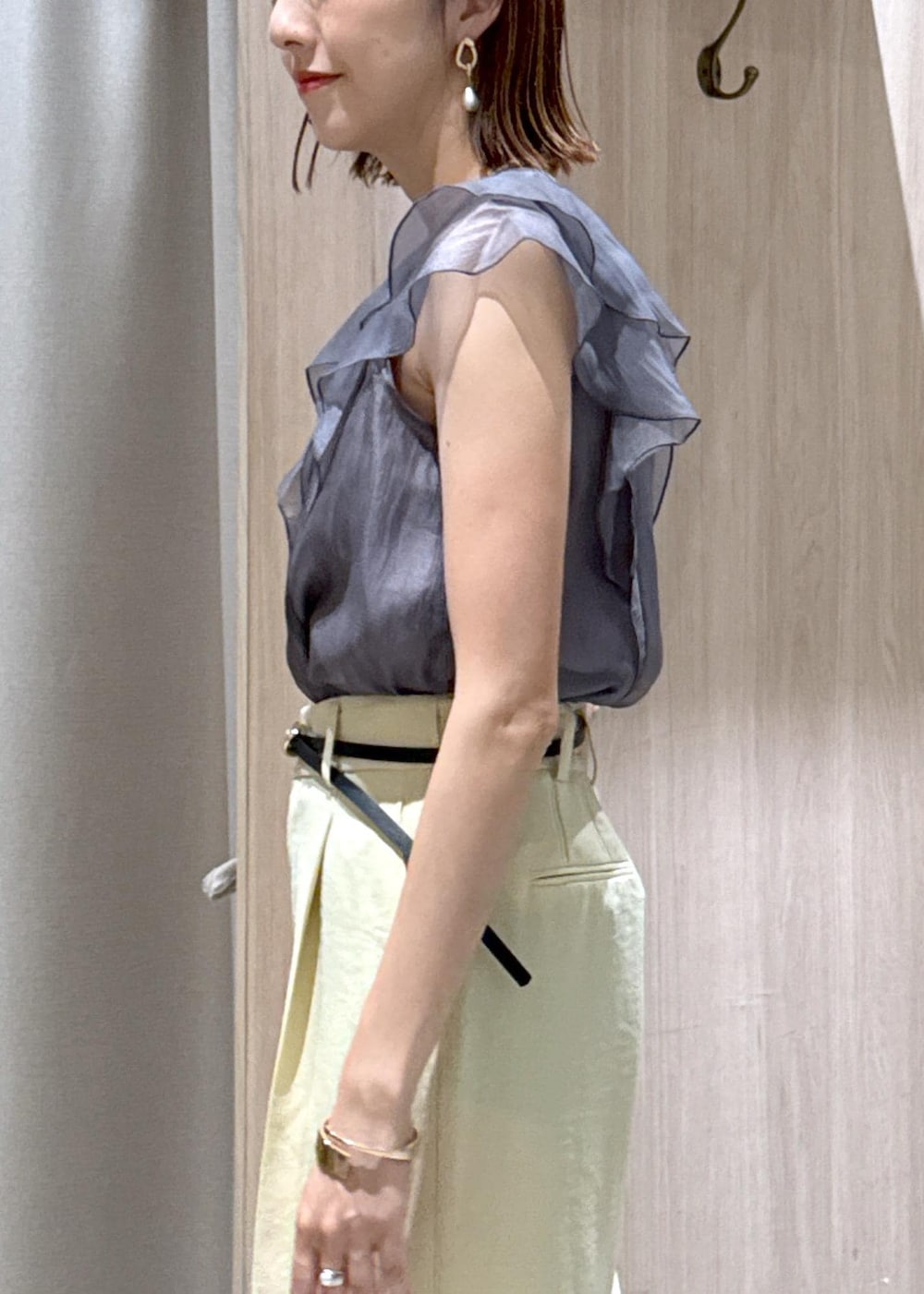 ホワイト系のショルダーバッグ、ホワイト系のサンダル、イエロー系のスラックスを着用したレディースの夏コーディネートの8枚目の写真