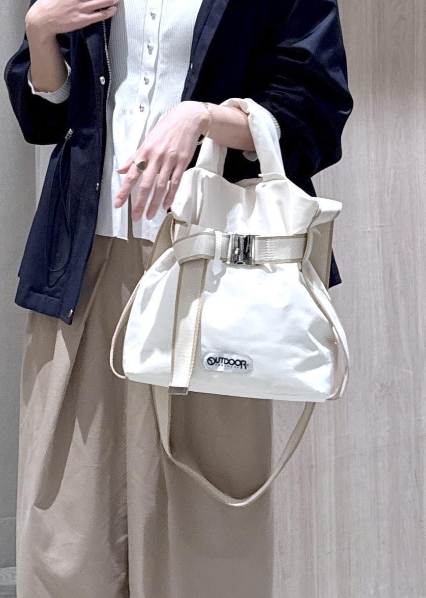 ホワイト系のカーディガン/ボレロ、ホワイト系のトートバッグ、ブルー系のナイロンジャケットを着用したレディースの春コーディネートの5枚目の写真