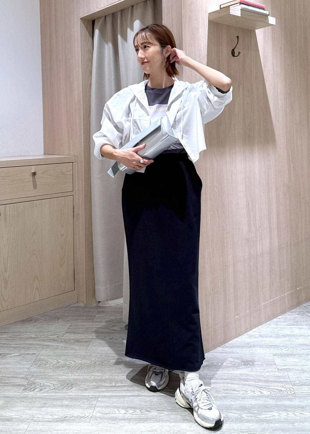 シルバー系のショルダーバッグ、ブラック系のスカート、グレー系のTシャツ/カットソーを着用したレディースの秋コーディネートの2枚目の写真