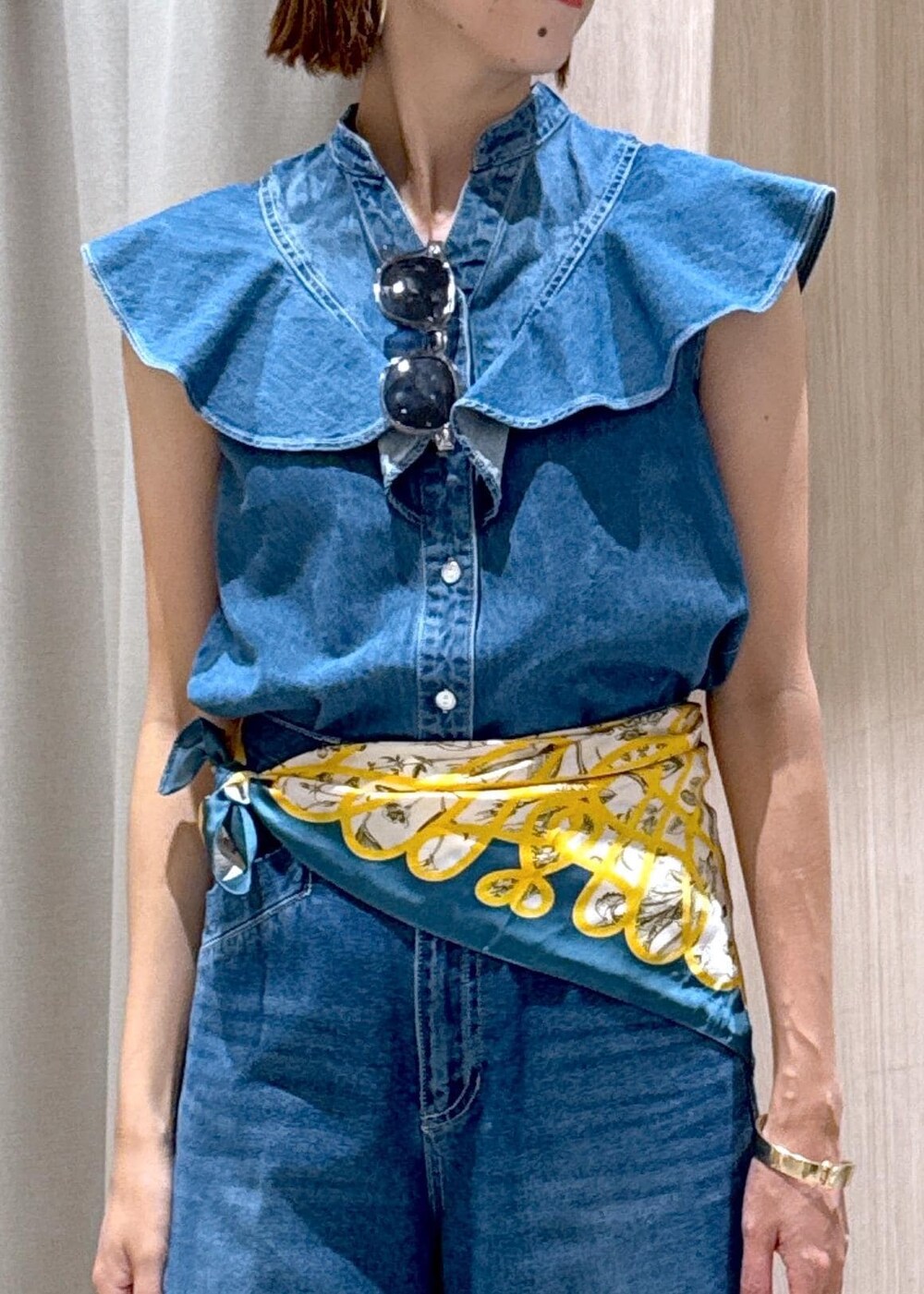 シルバー系のハンドバッグ、ブルー系のシャツ/ブラウス、ブルー系のデニムパンツを着用したレディースの夏コーディネートの8枚目の写真