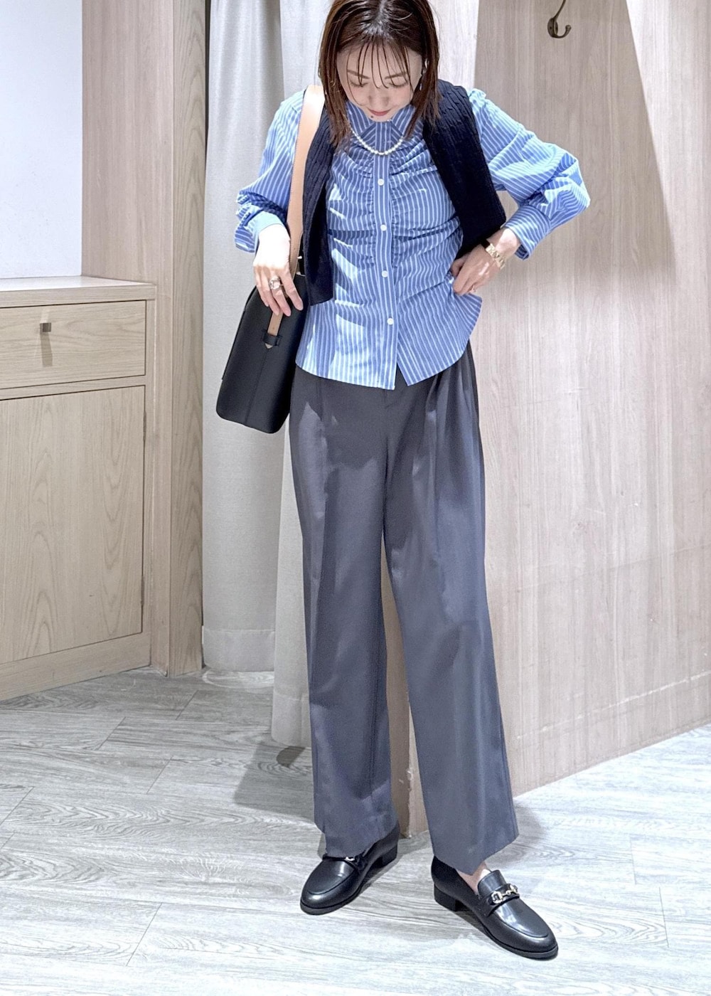 ブラック系のトートバッグ、ブルー系のカーディガン/ボレロ、グレー系のその他パンツを着用したレディースの冬コーディネートの4枚目の写真