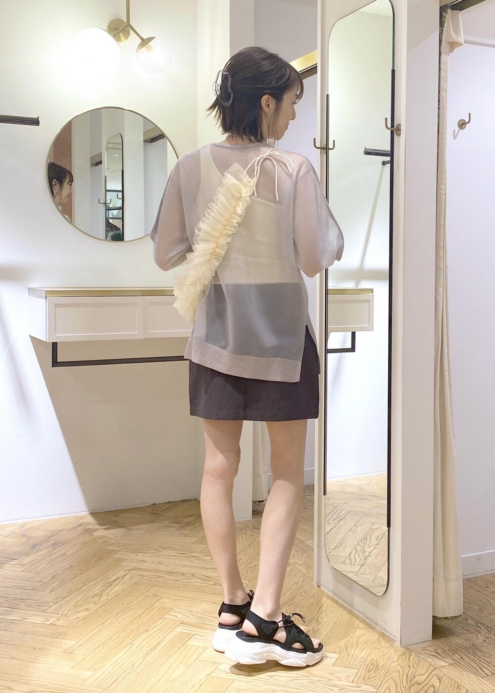 ブラック系のサンダル、グレー系のスカート、ホワイト系のタンクトップを着用したレディースの春コーディネートの2枚目の写真