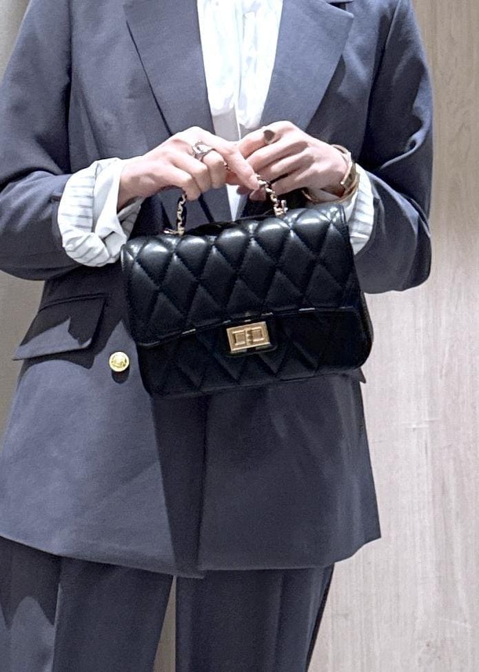 ブラック系のショルダーバッグ、グレー系のその他パンツ、グレー系のテーラードジャケットを着用したレディースの冬コーディネートの10枚目の写真