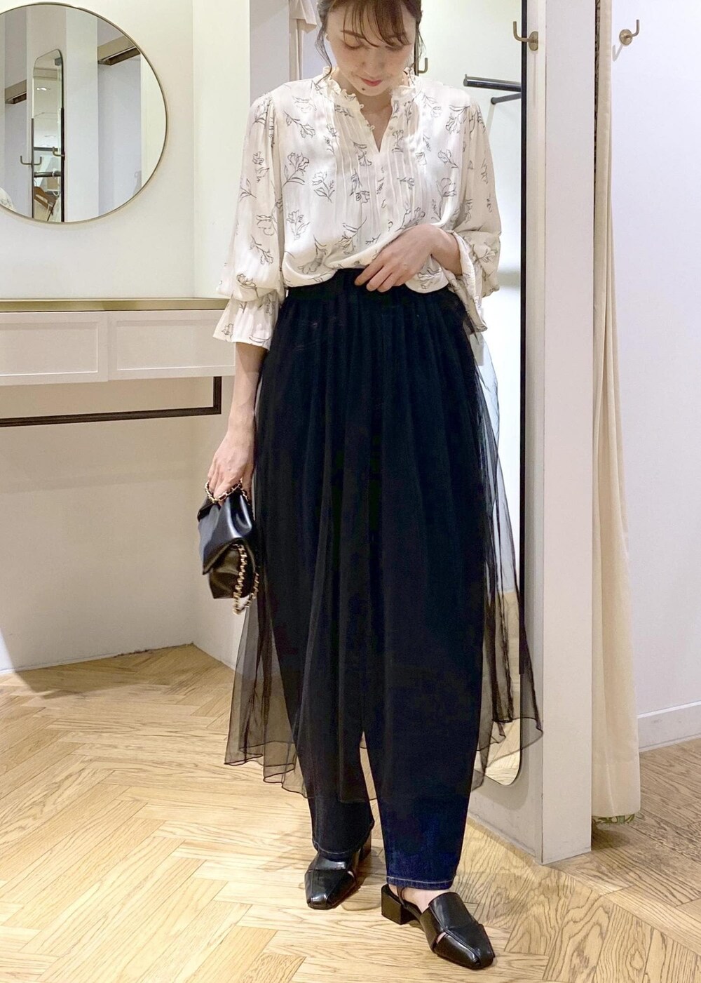 ブラック系のサンダル、ブラック系のスカート、ホワイト系のシャツ/ブラウスを着用したレディースの春コーディネートの3枚目の写真