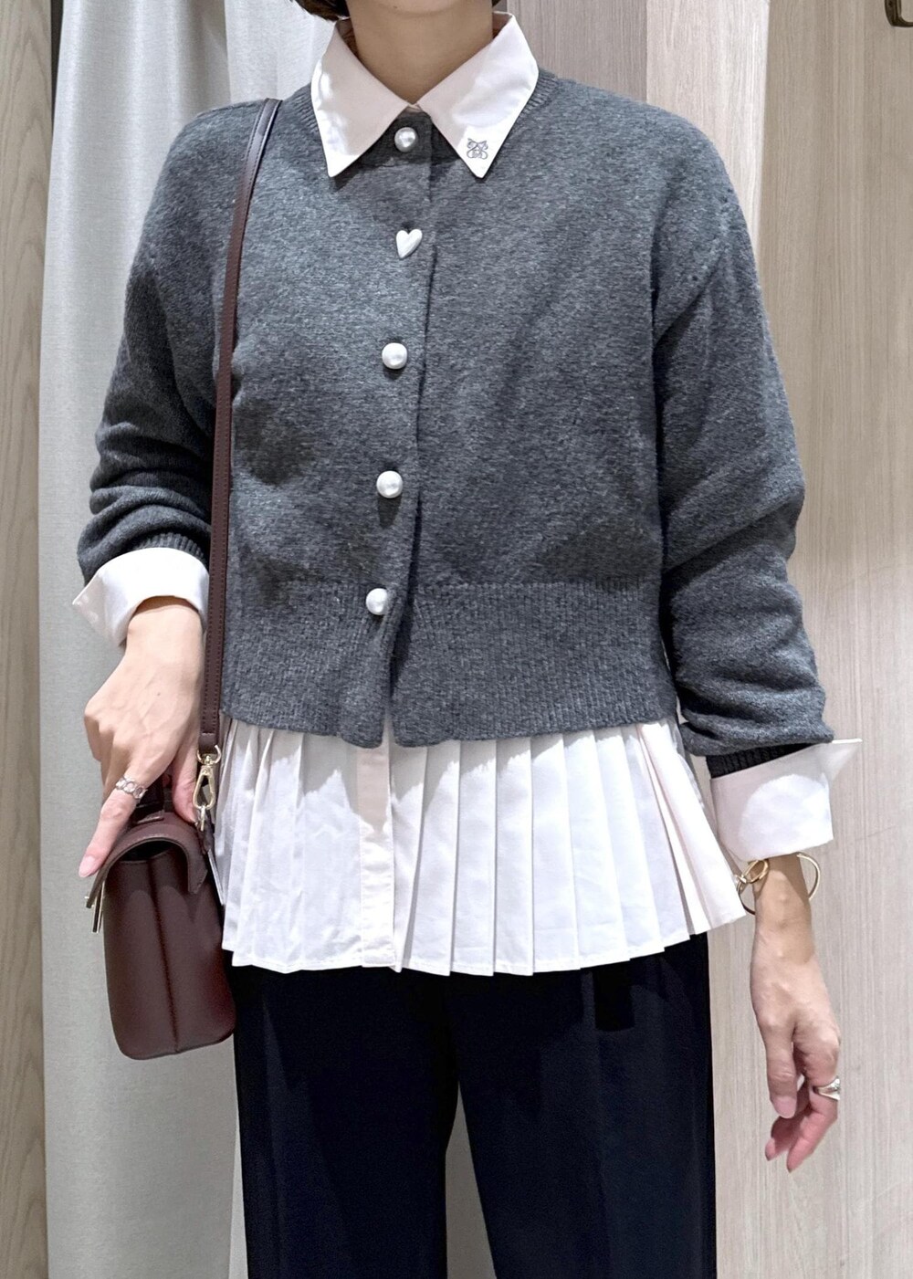 ブラウン系のショルダーバッグ、ブラック系のスラックス、グレー系のカーディガン/ボレロを着用したレディースの秋コーディネートの8枚目の写真