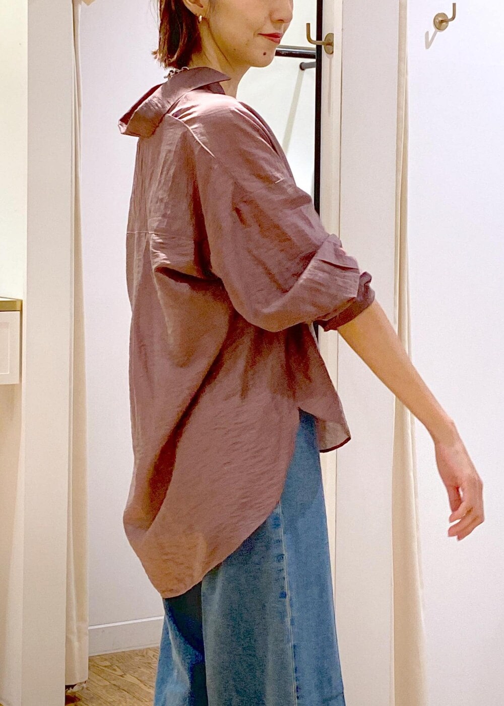 ブラック系のキャミソール、ホワイト系のショルダーバッグ、ブルー系のデニムパンツを着用したレディースの秋コーディネートの6枚目の写真