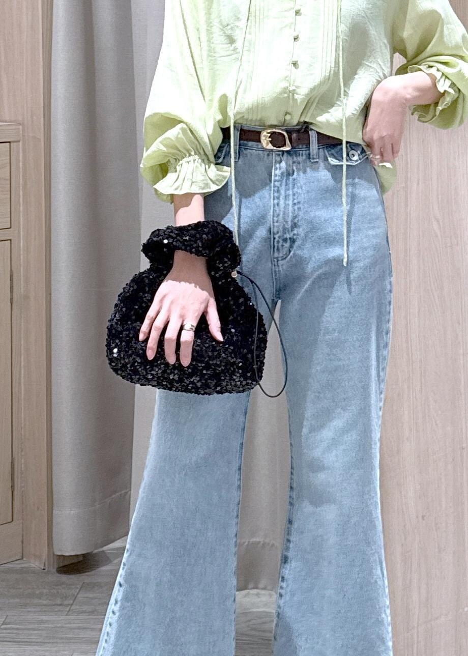 ブルー系のデニムパンツ、ブラウン系のパンプス、ブラック系のハンドバッグを着用したレディースの春コーディネートの7枚目の写真