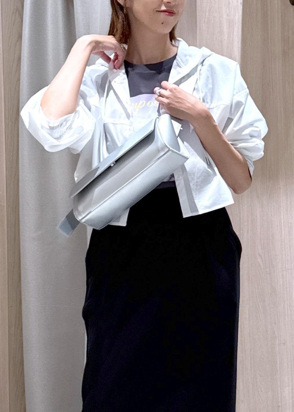 シルバー系のショルダーバッグ、ブラック系のスカート、グレー系のTシャツ/カットソーを着用したレディースの秋コーディネートの7枚目の写真