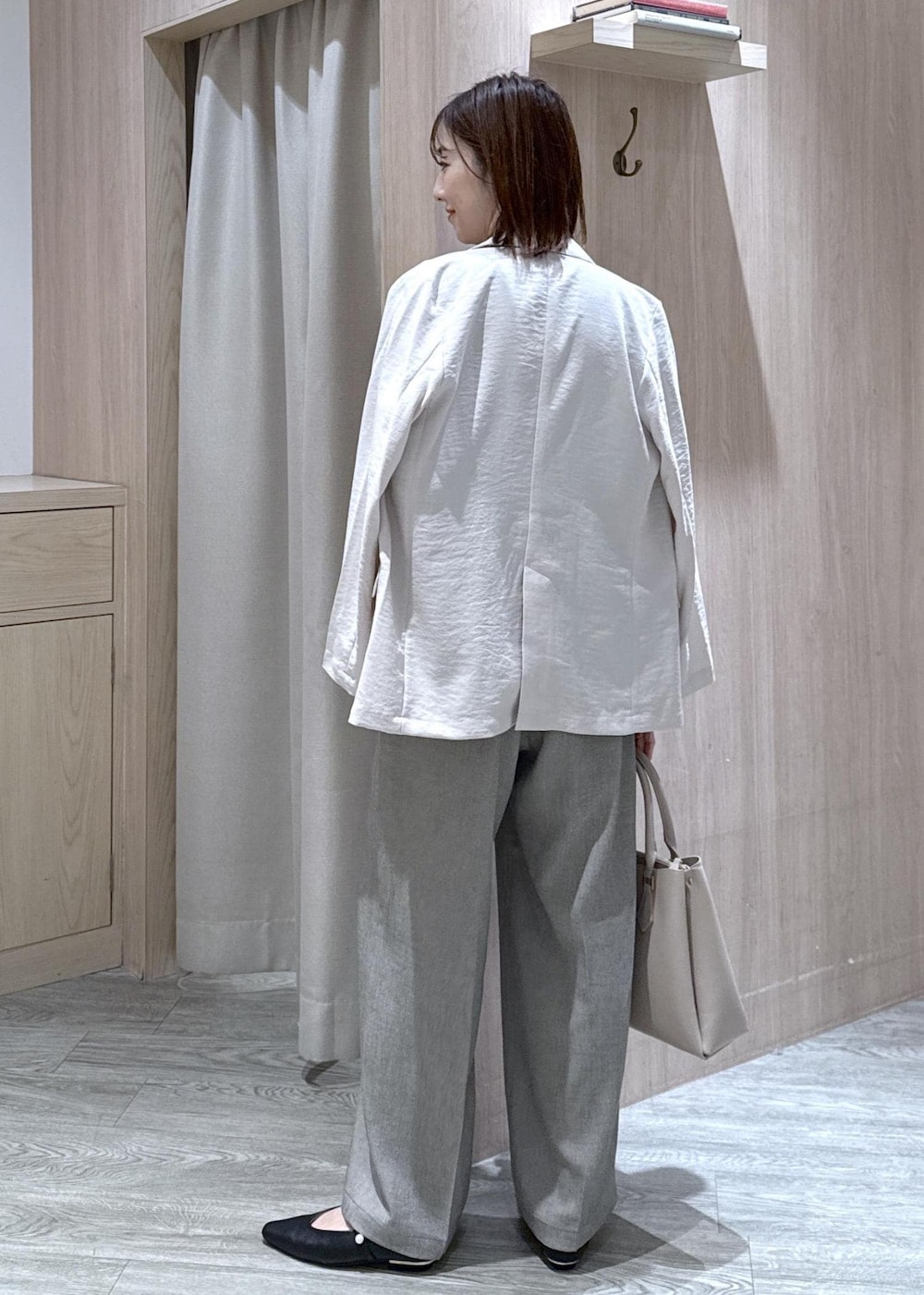 ブラック系のパンプス、グレー系のその他パンツ、ホワイト系のテーラードジャケットを着用したレディースの春コーディネートの4枚目の写真