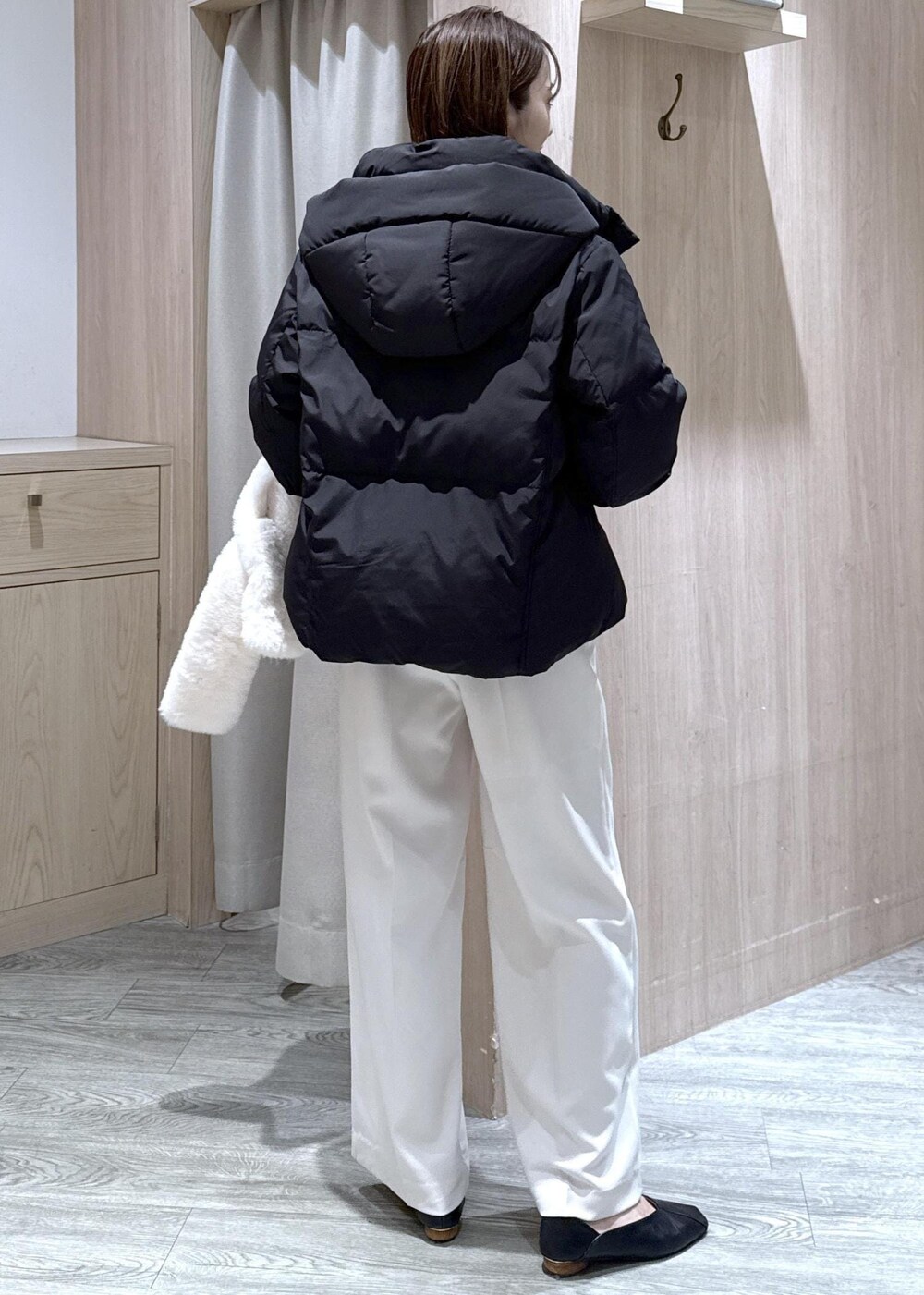 ブラック系のダウンジャケット/コート、ホワイト系のスラックス、ブラック系のニット/セーターを着用したレディースの冬コーディネートの3枚目の写真