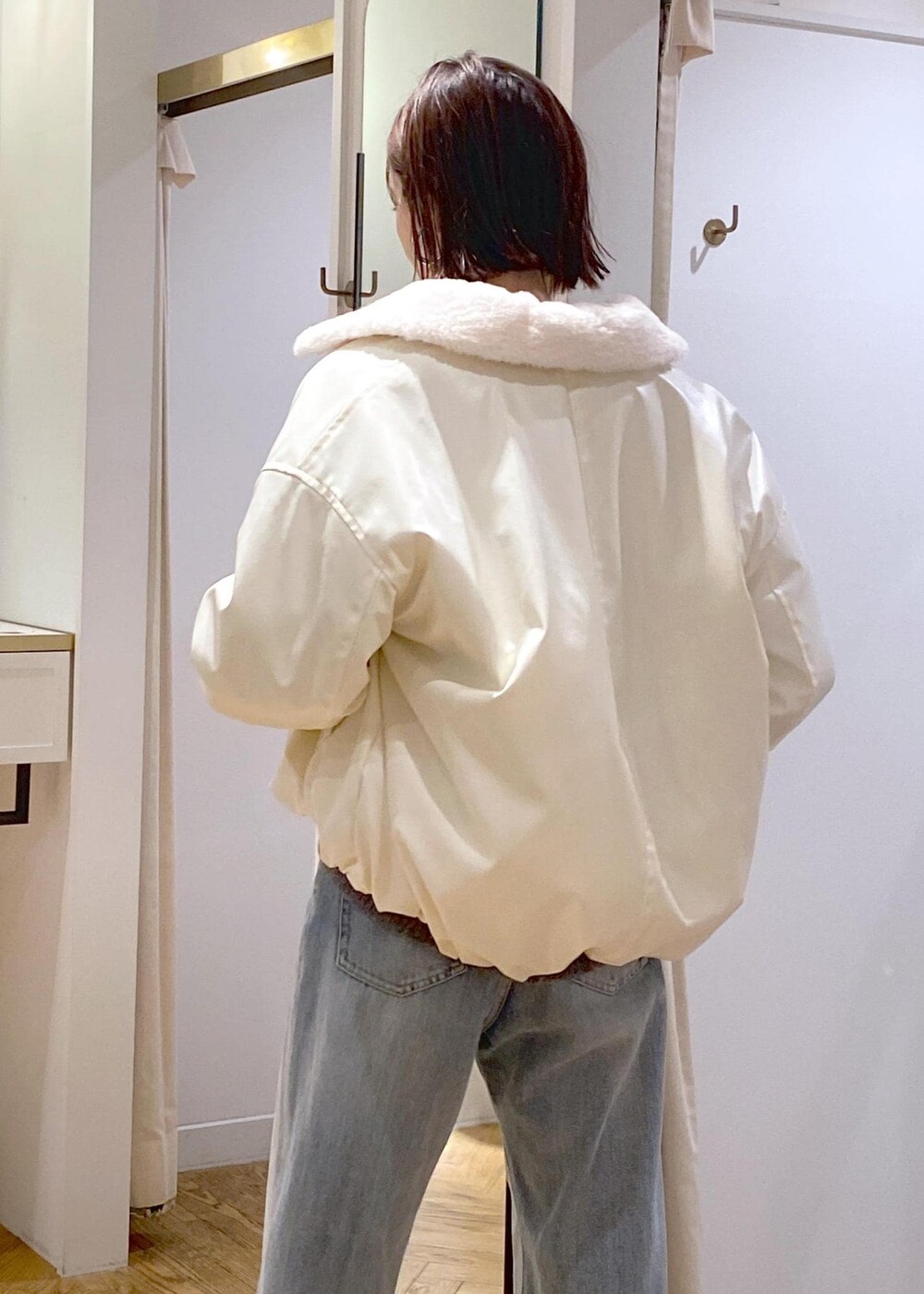 シルバー系のショルダーバッグ、ブルー系のデニムパンツ、グレー系のカーディガン/ボレロを着用したレディースの冬コーディネートの8枚目の写真