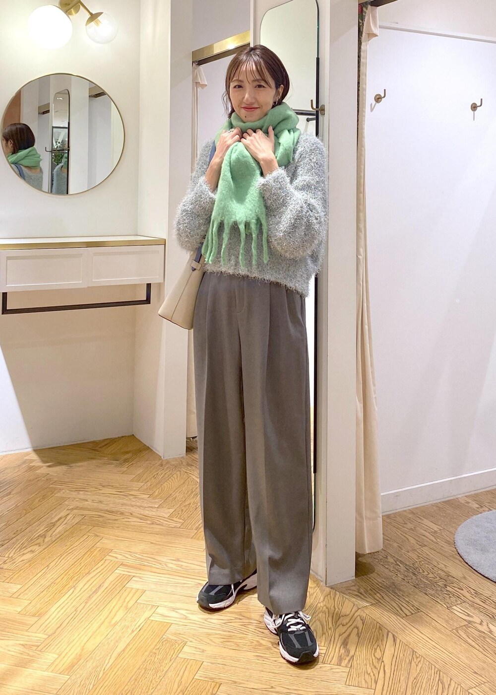 ベージュ系のショルダーバッグ、グレー系のスラックス、グリーン系のニット/セーターを着用したレディースの冬コーディネートの6枚目の写真