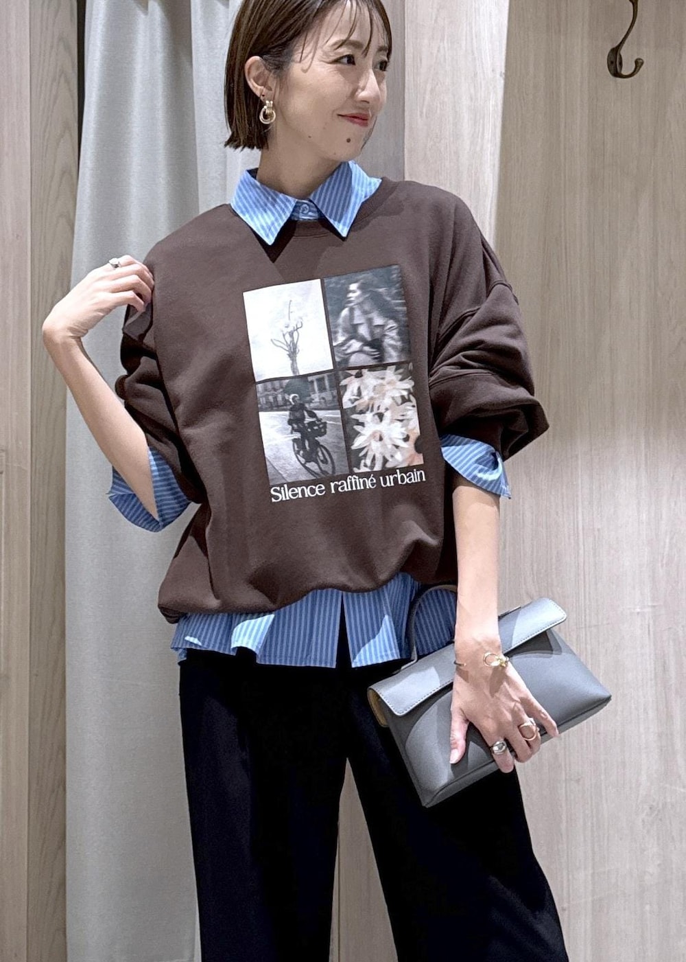 グレー系のショルダーバッグ、ブラック系のスラックス、ブルー系のシャツ/ブラウスを着用したレディースの秋コーディネートの5枚目の写真