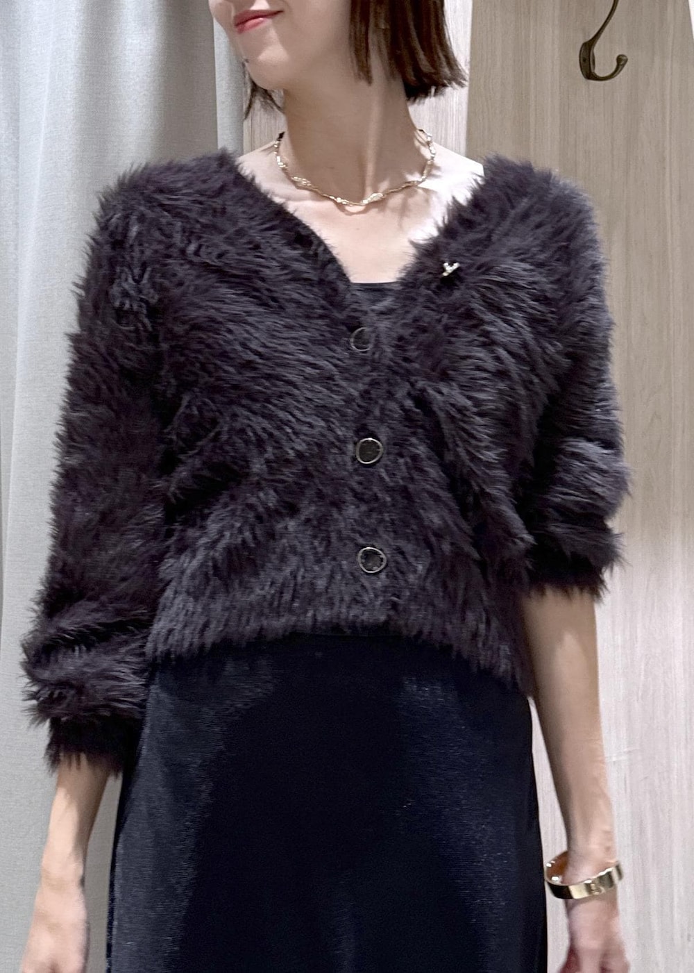 ベージュ系のショルダーバッグ、グレー系のその他アウター、ブラック系のスカートを着用したレディースの冬コーディネートの7枚目の写真