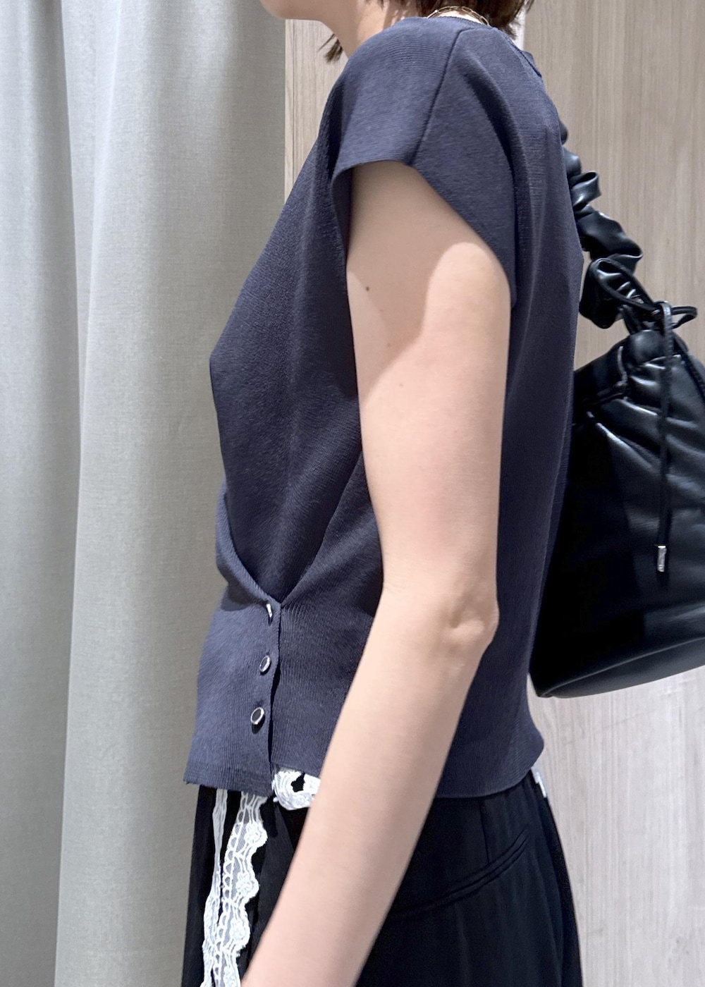 ブラック系のショルダーバッグ、ブラック系のパンプス、グレー系のニット/セーターを着用したレディースの夏コーディネートの7枚目の写真